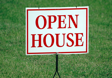 An 'Open House' sign against green grass.